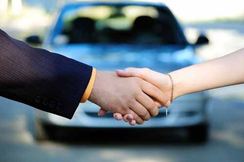 A Nebraska Motor Vehicle Dealer shakes hands with a customer