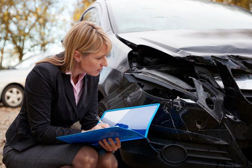  A Tennessee Public Adjuster examines damage to a car